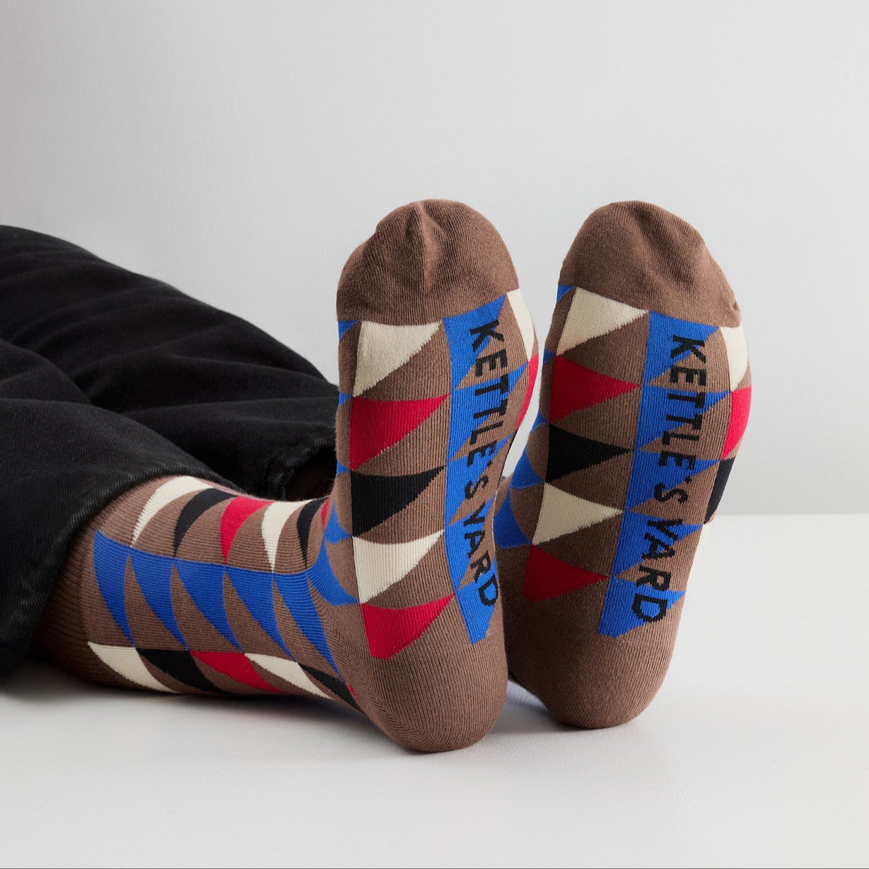Colorful patterned socks with 'Kettle's Yard' branding on a white background